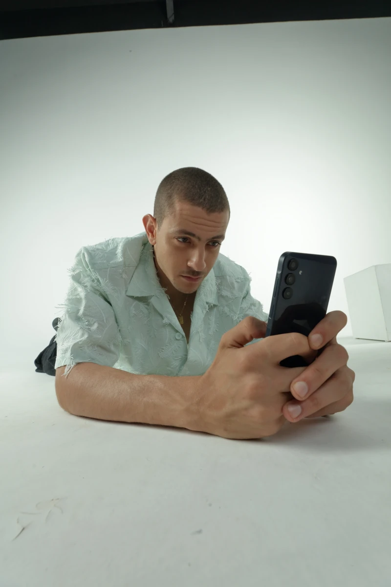 Fares Abdeddayem using the Galaxy A15 on a white studio floor